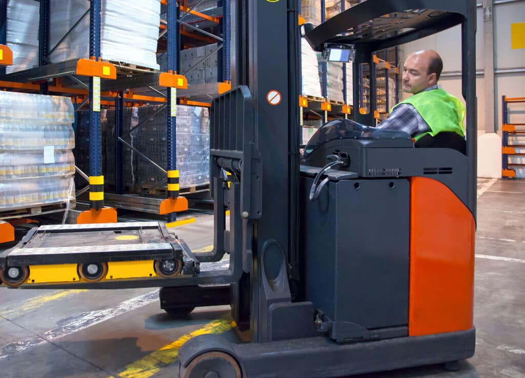 Forklift with shuttle pallet in distribution warehouse